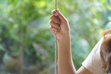 Female human hand holding a swing rope