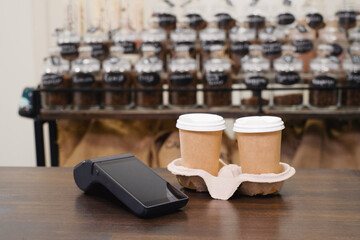 Customer using smartphone and nfs technology to pay barista for purchase with phone at a cafe for coffee. Safe transaction 