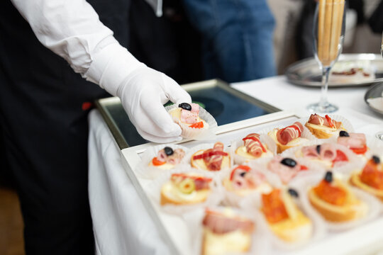 Professional placing food on table. Canape buffet appetizer meal event concept.
