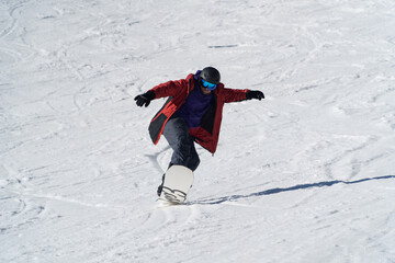 man snowboarding on the mountain on a sunny day