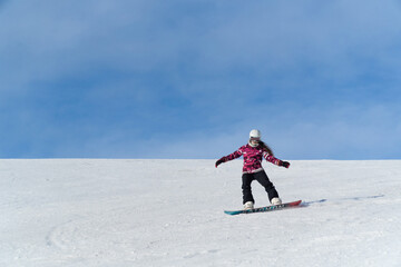 Fototapeta na wymiar Girl snowboarding in the snow on the mountain on a sunny day