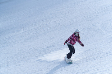 Fototapeta na wymiar Girl snowboarding in the snow on the mountain on a sunny day