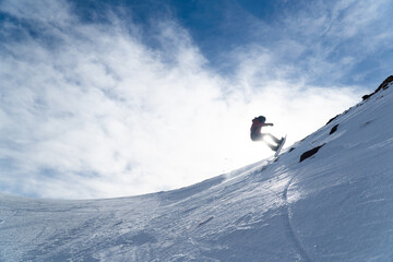 Naklejka na ściany i meble man snowboarding on the mountain on a sunny day