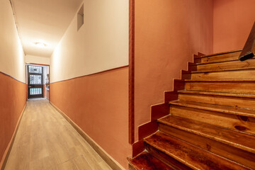 Portal of an old house with a long corridor and stairs made of varnished wood