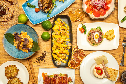 Top view image of nice spanish food dishes, burgers and tapas on wooden table