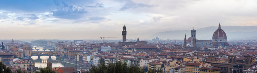 Evening Florence City top view (Italy, Tuscany) on Arno river. Panorama. All people are unrecognizable. In center:  Palazzo Vecchio (town hall) and Florence Cathedral (on right). 