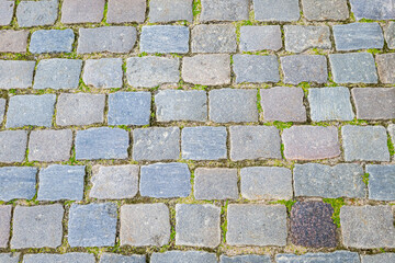 Granite dirty paving stones in the city. Road from paving stones for background and texture. The old road of granite paving stones