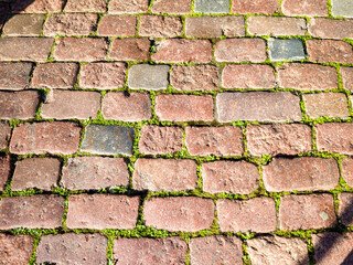 Granite dirty paving stones in the city. Road from paving stones for background and texture. The old road of granite paving stones