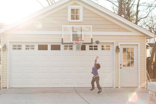 Full length of boy playing basketball in drive way