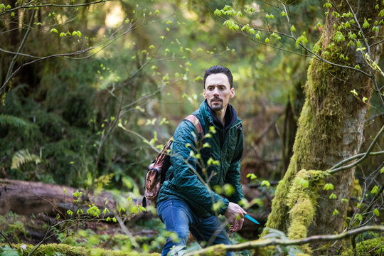 Man focusing on target during disk golf game in the forest.