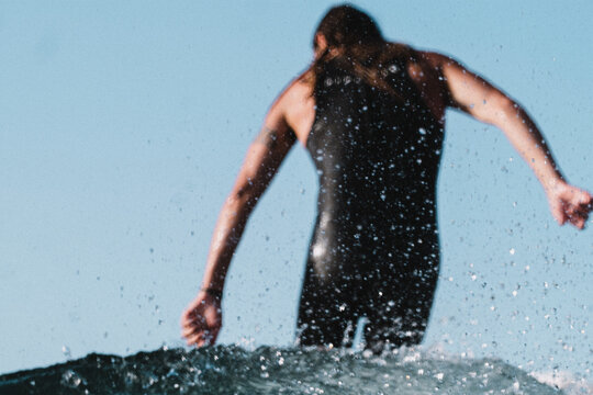Blurred male surfer seen from behind