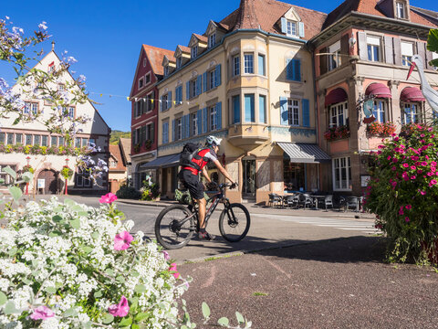 Man riding electric mountain bike through the commune of Munster, Haut-Rhin, Vosges, France