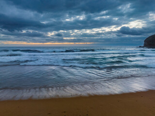 Fototapeta na wymiar Sunrise over the ocean with rain clouds