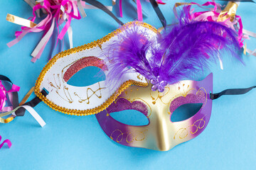 Festive face mask for carnival celebration on blue background. Mardi gras carnival background with...
