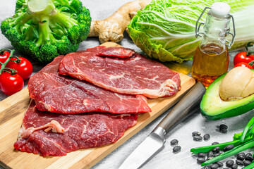 Organic food. Raw beef meat with healthy green food.