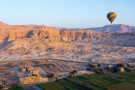 Colorful hot air balloon at sunrise in front of Temple of Hatshepsut and Ramesseum near the Valley of the Kings in Luxor, Egypt