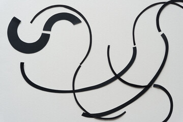 wavy paper lines composed of cut paper rings and ovals on blank paper