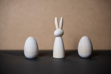 petite silhouette de lapin en bois dans un décor sobre avec deux oeufs de Pâques en bois