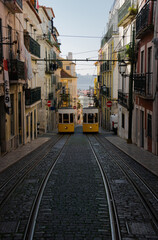 typical yellow trams of lisbon that exchange symmetrically parallel on the street with in the street