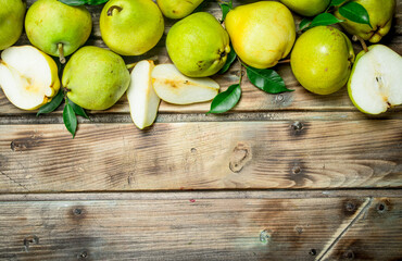 Pieces of and whole fresh pears with leaves.