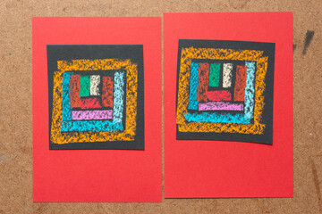 two abstract black paper boxes with lines on red cards and board