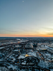 Aerial image of the Henry Doorly Zoo and Aquarium Omaha Nebraska Zoo Futuristic dome in the winter covered in snow at sunset