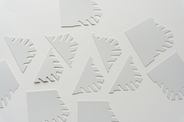 gray paper shapes with short fringes on blank paper