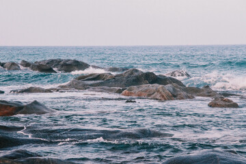 The scene of waves crashing against rocks on the coast of Vietnam
