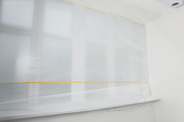Window covered with polyethylene film. Protection during repair