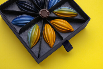 Box of tasty chocolate candies on yellow background, above view