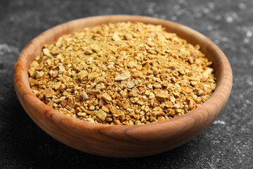 Bowl of dried orange zest seasoning on grey table, closeup