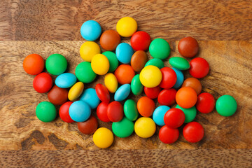 Fototapeta na wymiar Tasty colorful candies on wooden table, flat lay