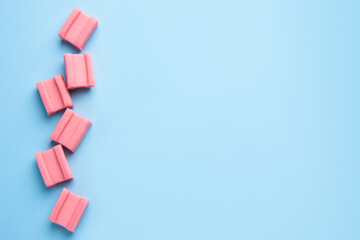 Tasty chewing gums on light blue background, flat lay. Space for text