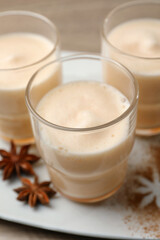 Delicious eggnog with anise on wooden table