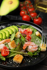 Delicious salad with croutons, avocado and shrimp served on table, closeup