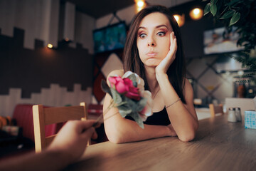 Surprised Woman Receiving Flowers on the First Date in a Restaurant. Sad girlfriend thinking about...