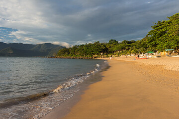 Praia do Curral no cair da tarde - ILHABELA, SP, BRAZIL - DECEMBER 01, 2022: Praia do Curral (Curral beach) in the golden dusk of this beautiful island town.
