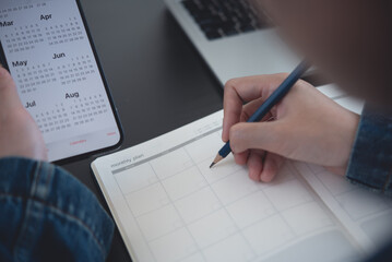 2023 Calendar event planner timetable agenda plan on organize schedule. Business woman using mobile phone with monthly calendar for event planning, Plan scheduling on notebook at office