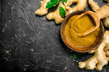 Ground ginger in wooden bowl with scoop.