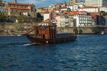 Antique boat on the Douro River in Porto Portugal with the cityscape background