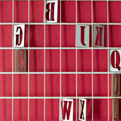 wood grid or lattice with random letters on red scrapbook paper