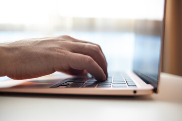 Purchases via the Internet and payment for services buy credit card. Hands type text and enter data on the laptop keyboard. An office worker checks his email while sitting at his desk