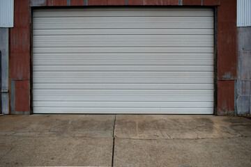 Fototapeta na wymiar Clean white warehouse rolling door of old storage building