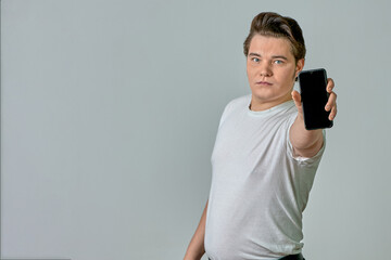 A man at arm's length shows a phone screen on a gray background