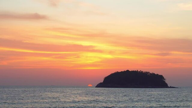 .scenery yellow sun going down to the sea..beautiful moving cloud in sweet sky at sunset in Kata beach Phuket Thailand.4k stock footage video in travel concept.