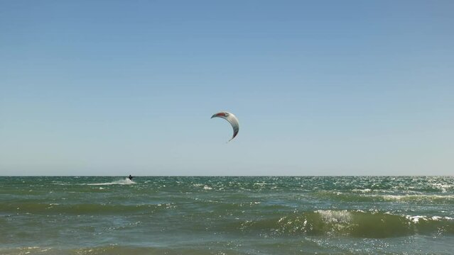 Wind Surfer rides waves on clear blue sky day Grange Beach South Australia
