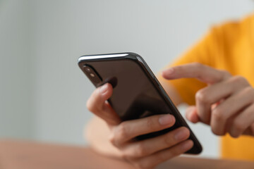Hand holding smartphone with using social media on internet on table.