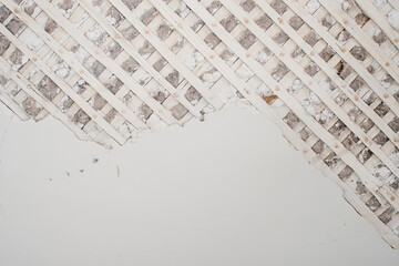 The plaster has fallen off the wall. Close-up of the old wall of the room