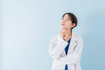 考える白衣を着た日本人女性