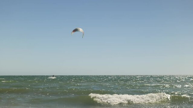 Wind Surfer rides waves on clear blue sky day in 
Slow Motion Grange Beach South Australia
